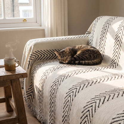 Tabby cat asleep on an armchair covered with the cream herringbone jacquard sofa cover