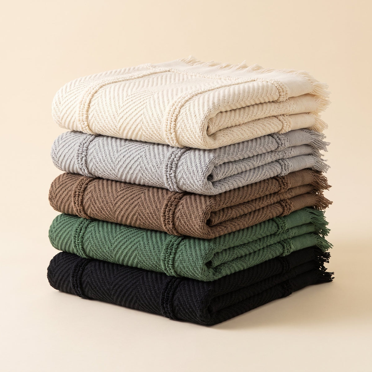 Herringbone jacquard sofa covers folded in a stack in cream, gray, coffee, green and black