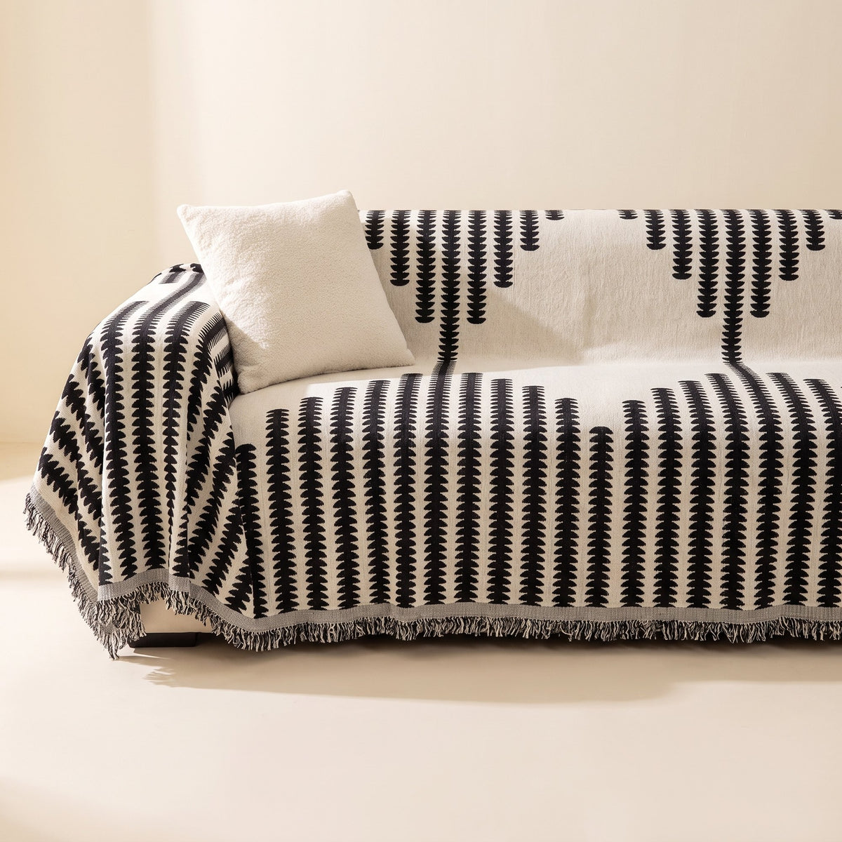 Chenille sofa cover in black on cream draped over a three-seater sofa