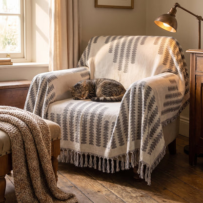 Tabby cat asleep on an armchair covered with the gray chenille sofa cover
