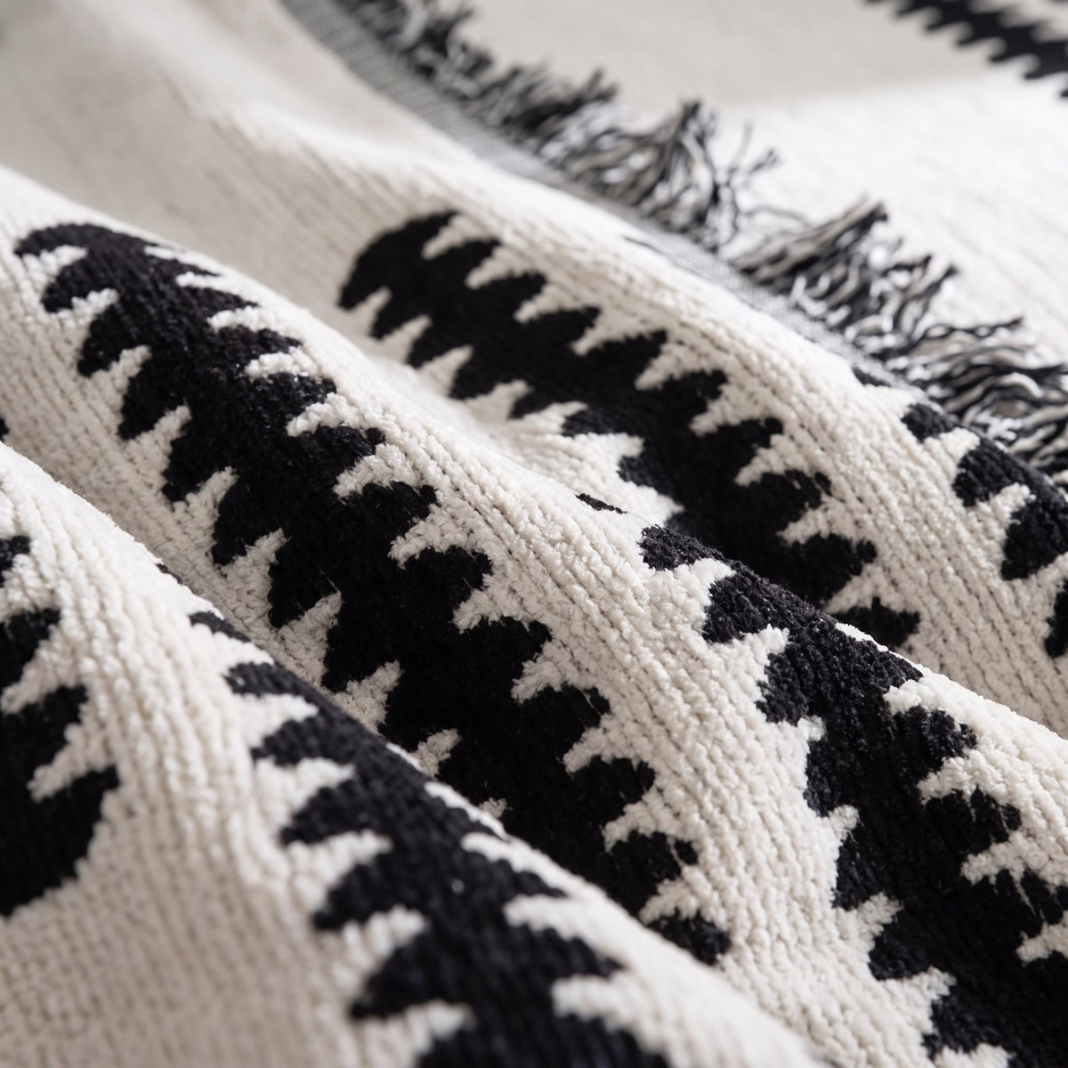 Close-up of the soft chenille weave and fringed edge of the sofa cover