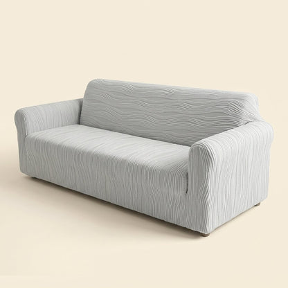 Stretch jacquard sofa cover in light grey fitted on a three-seater sofa, cream studio background