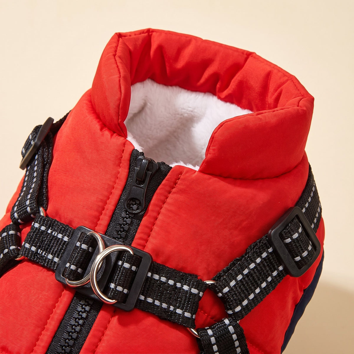 Close-up of the winter dog jacket's high padded collar with white plush lining, back zip and metal D-rings